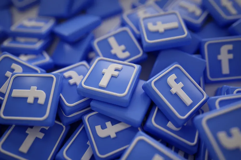 Stacks of 3D Facebook icons on a blue background.